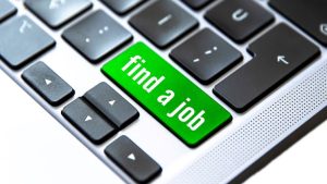 A green button on a laptop computer that reads "find a job"