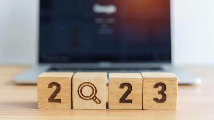 2023 in block letters on desk in front of an open laptop computer.