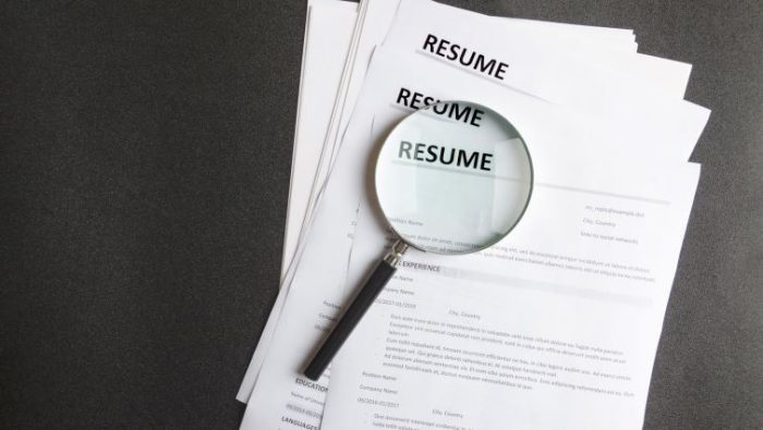 A resume with a magnifying glass over the resume headline.