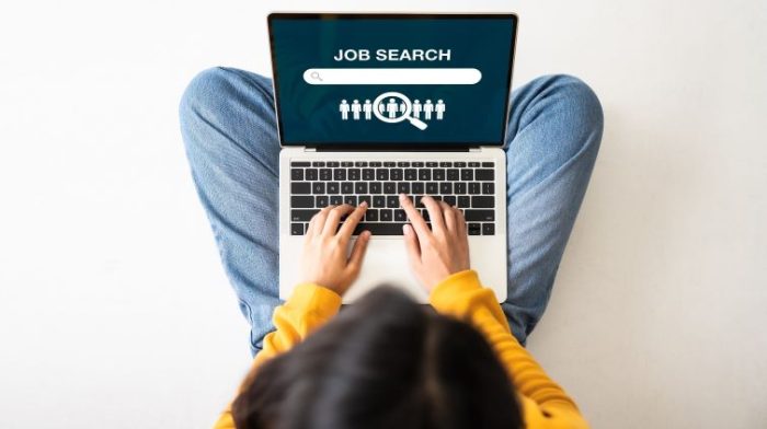 How to Find a Job with No Experience As a New Graduate - a young graduate searching for jobs on their laptop computer.