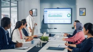 What is Collaborative Analysis, and Why Do Companies Need It - a workplace team is in a meeting reviewing charts of data.