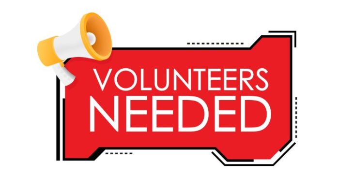 8 Ways Volunteering Can Boost Your Professional Network - a red and white VOLUNTEERS NEEDED signs with a big megaphone next to it.