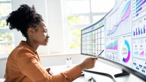 What are the Different Types of HR Analytics - an HR manager reviews various forms of data on an extended computer screen.