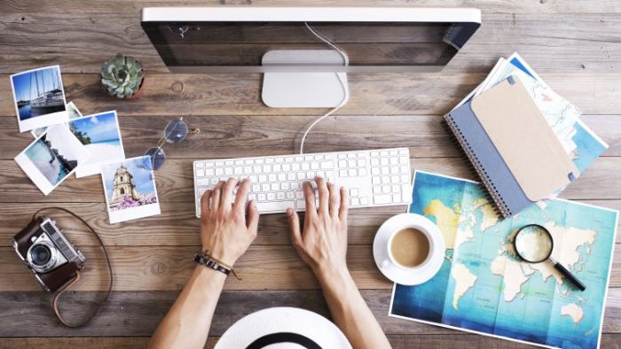 Post-Vacation Productivity - 5 Effective Tactics for a Smooth Return - a professional working at their desk surrounded by vacation photos.