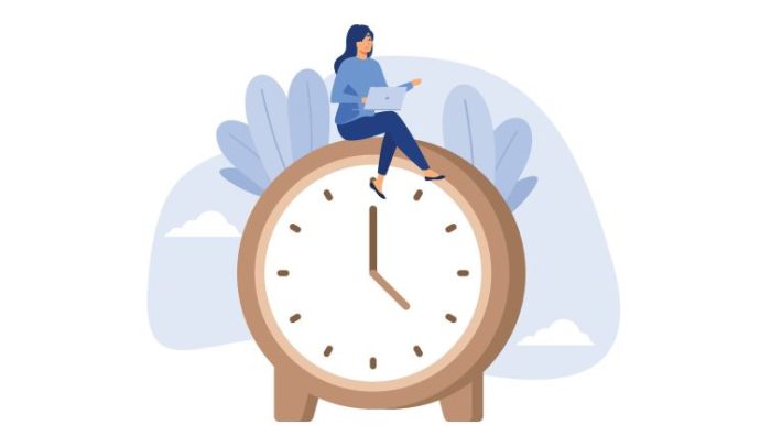 The Psychological Impact of Long-Term Remote Work - a remote worker typing on a laptop while sitting on top of a giant clock.