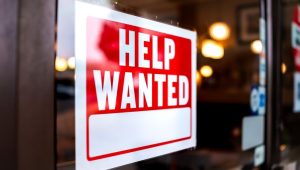 The Most In-Demand Jobs in Canada in 2024 - A help wanted sign on the door of a business.