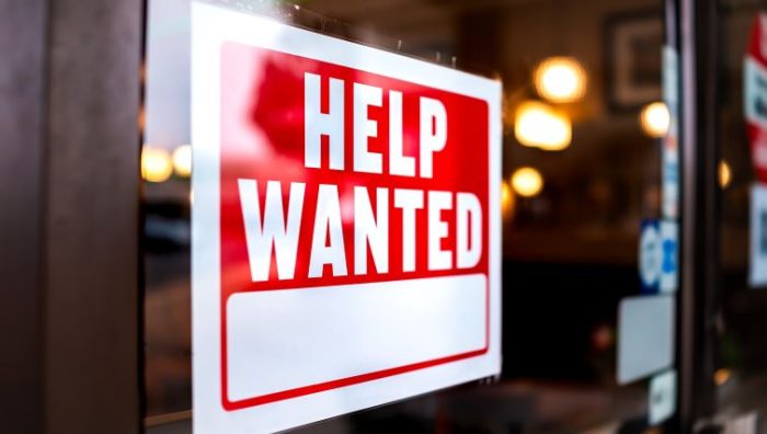 The Most In-Demand Jobs in Canada in 2024 - A help wanted sign on the door of a business.
