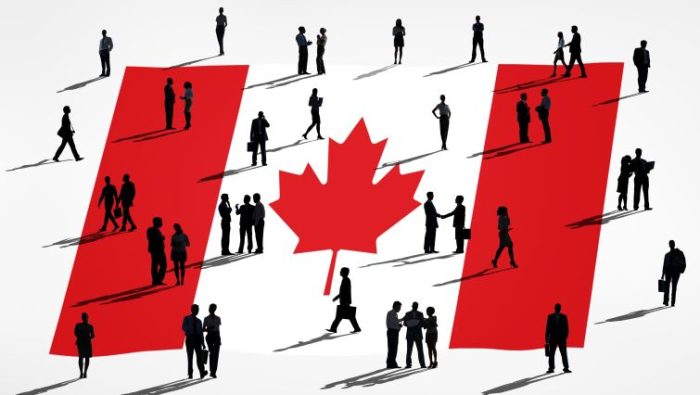 10 Reasons To Live and Work in Canada in 2024 - a diverse group of people standing around a Canadian flag as they build successful lives.