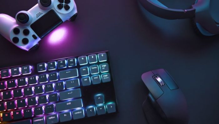 How Gamification in the Workplace Can Help Alleviate Remote Worker Burnout - a work computer on a desk with a video game controller next to it.