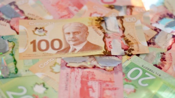 The 2024 Minimum Wage in Canada 1 - a pile of money made of various bills.