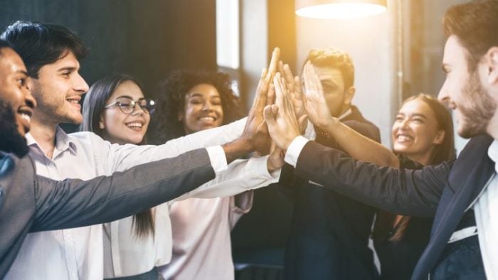 6 Ways to Leverage Employee Feedback Loop and Promote Development - a group of happy employees giving each other feedback.